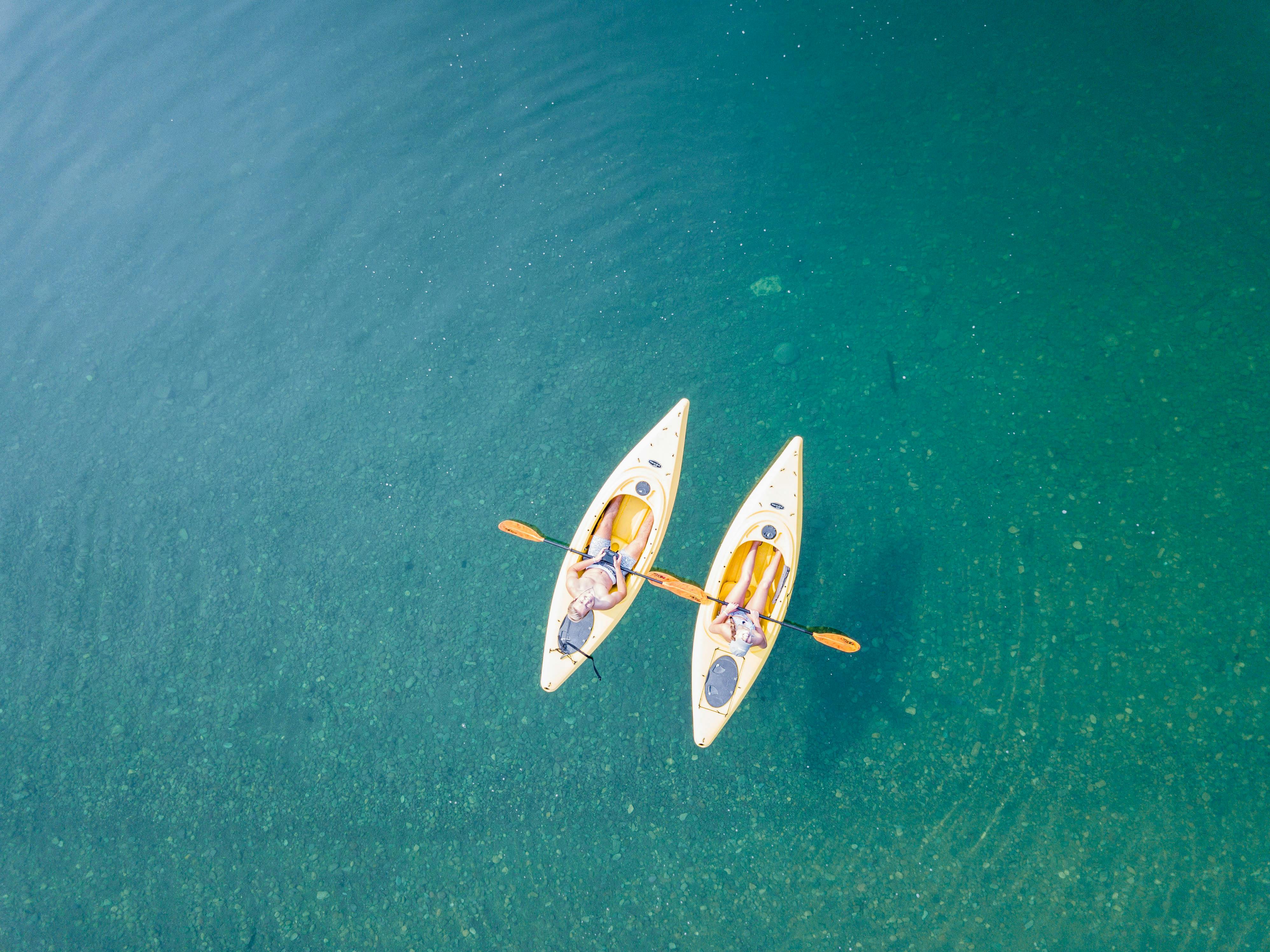 bird’s eye view of two people kayaking on a body of water