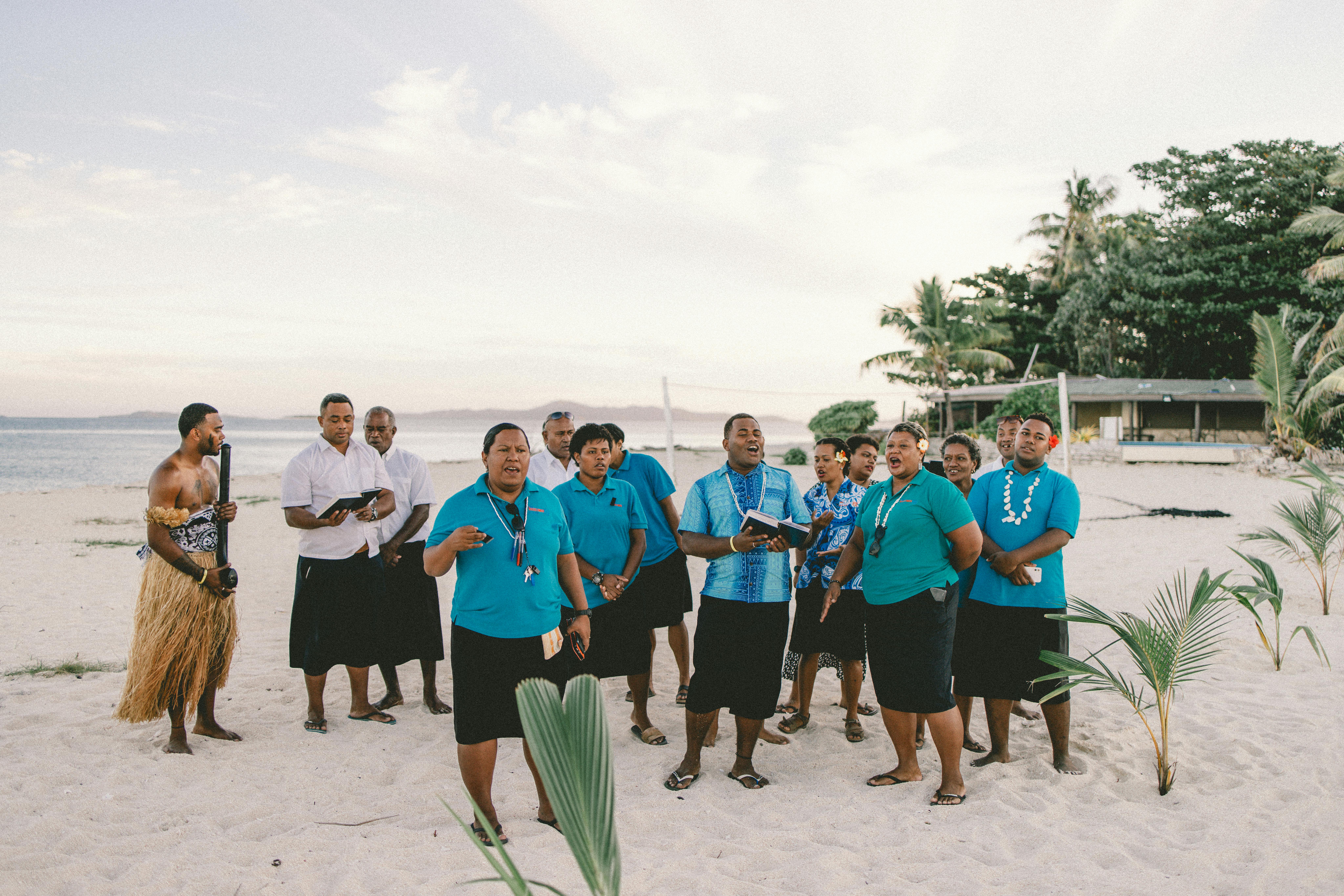 a group of people singing on a beach