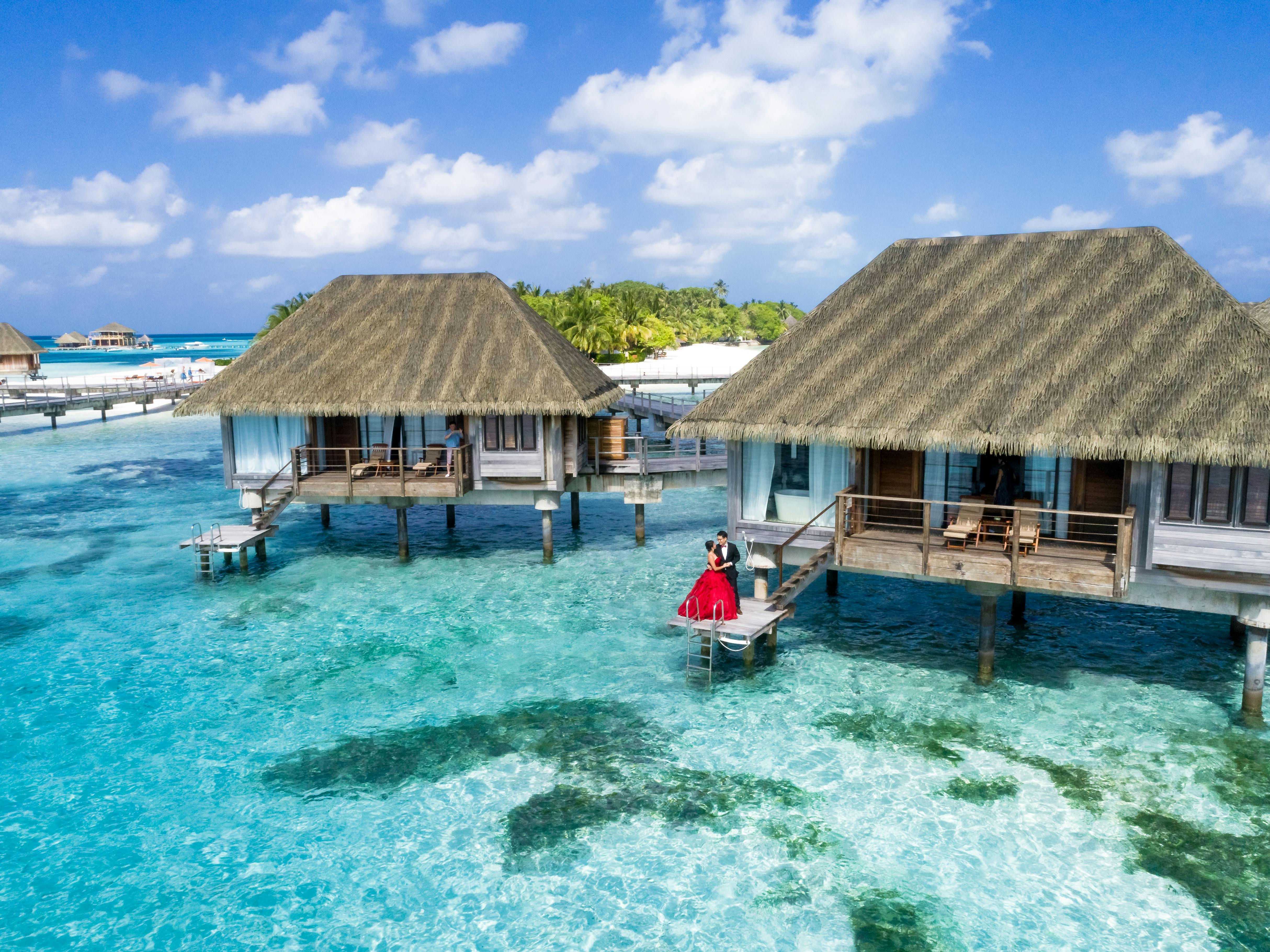 Man and woman standing on the deck of an overwater bungalow